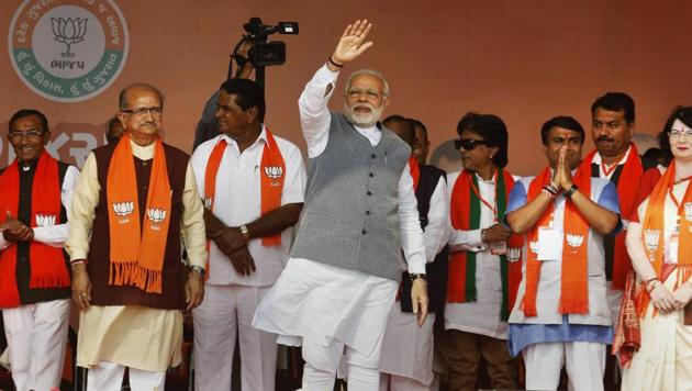 Prime Minister Narendra Modi waves at a crowd during an election rally in support of BJP candidates, in Sanand on Sunday.(PTI)