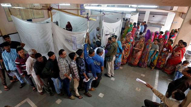 People stand in queues to cast their votes inside a polling booth during the first phase of state assembly election in Limbdi town of Surendranagar district in Gujarat on December 9. (REUTERS) People stand in queues to cast their votes inside a polling booth during the first phase of state assembly election in Limbdi town of Surendranagar district in Gujarat on December 9. (REUTERS)