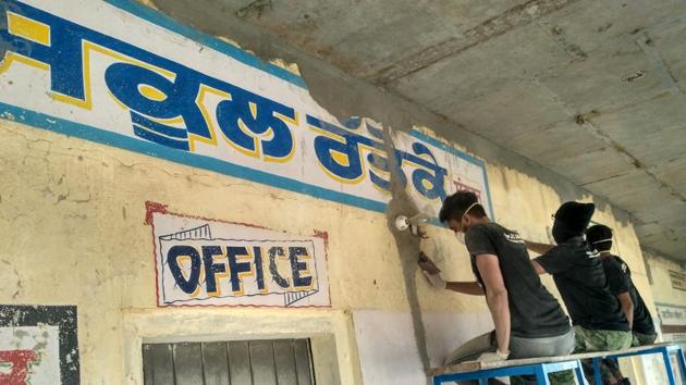 Youths painting a wall of Government Primary School, Rattoke, in Sangrur on Sunday.(HT Photo)