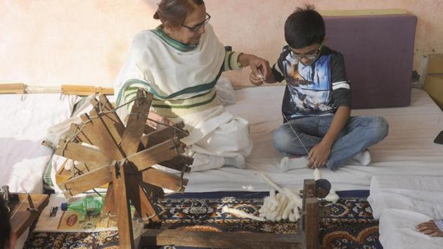 A child learns how to use the charka, or the spinning wheel, to weave a clothe. It was popularised by Mahatma Gandhi.(Sunil Ghosh/HT Photo)
