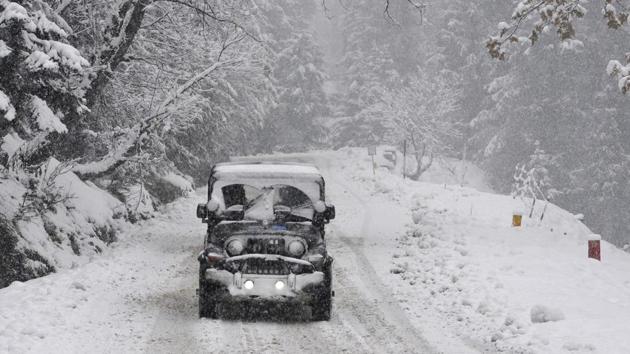 A vehicle drives past a snow-covered Gulmarg-Tangmarg road, about 38 kilometers from Srinagar, on Monday. (waseem andrabi/ht) A vehicle drives past a snow-covered Gulmarg-Tangmarg road, about 38 kilometers from Srinagar, on Monday. (waseem andrabi/ht)