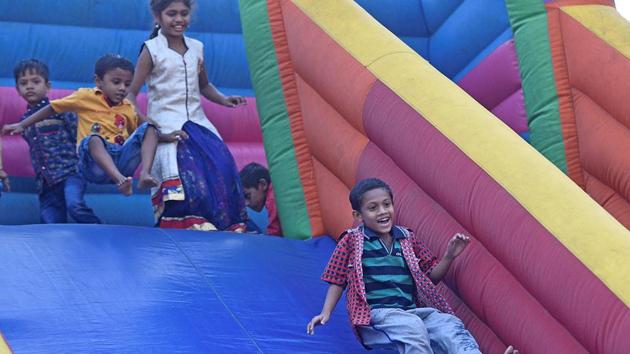 Children slide down an inflatable rainbow slide. (Shashi S Kashyap/HT PHOTO) 