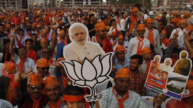 A girl holds cut out of Prime Minister Narendra Modi during an election campaign rally in Ahmadabad on December 8.(AP Photo)