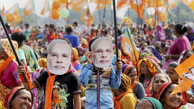 Supporters waer mask of Prime Minister Narendra Modi during an election campaign rally in support of BJP candidates, in Sanand on Sunday. (PTI) Supporters waer mask of Prime Minister Narendra Modi during an election campaign rally in support of BJP candidates, in Sanand on Sunday. (PTI)