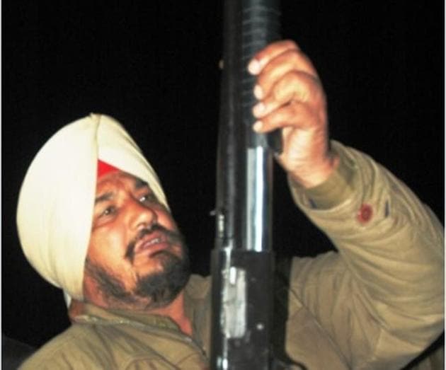 A policeman with a gun that was recovered from the spot where the shooting took place at Khaparkheri village near Amritsar on Wednesday (HT Photo) A policeman with a gun that was recovered from the spot where the shooting took place at Khaparkheri village near Amritsar on Wednesday (HT Photo)