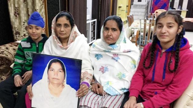 Family of Amrik Kaur, who died in 2014, with her photograph at their home in Amarkot, Tarn Taran, on Monday. (HT Photo) Family of Amrik Kaur, who died in 2014, with her photograph at their home in Amarkot, Tarn Taran, on Monday. (HT Photo)
