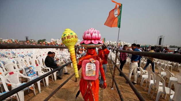 A supporter carries overhead a model of lotus, the election symbol of India's ruling Bharatiya Janata Party. (Reuters Photo)