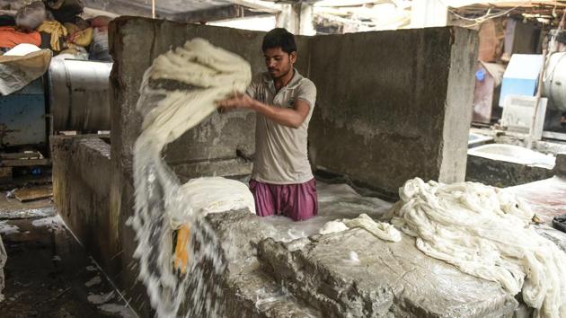 The day’s haul, once collected is brought to large cement tubs where it is treated with detergents. The next step moves the clothes to large vats where washermen --pants rolled up to their knees— stand soaking and rinsing them in water. The sound of clothes slapping against concrete fills the air.  (Burhaan Kinu / HT Photo) 
