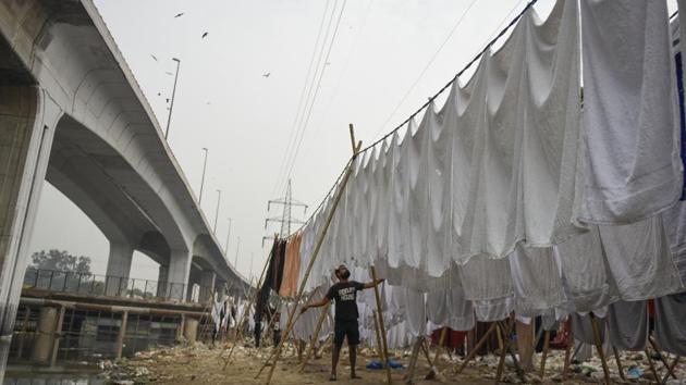 Modern technology and uncertain incomes while causes for concern, the traditional washermen at Jangpura’s Dhobi Ghat continue on at least for this winter –rows of fresh white linen a passing glimpse of their presence to those zipping by on the flyover above. (Burhaan Kinu / HT Photo) 