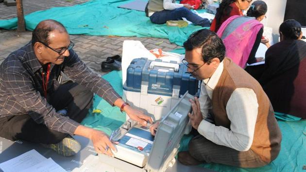Polling officials checking the electronic voting machines (EVMs) in Surat on Friday on the eve of the first phase of the Gujarat Assembly election.(PTI File Photo)