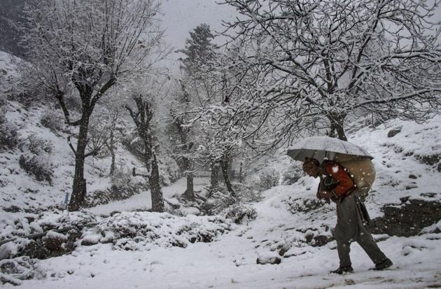 An elderly man, carrying a load on his back, walks on a snow covered road during snowfall at Tangmarg in Baramulla district of north Kashmir. (PTI) An elderly man, carrying a load on his back, walks on a snow covered road during snowfall at Tangmarg in Baramulla district of north Kashmir. (PTI)
