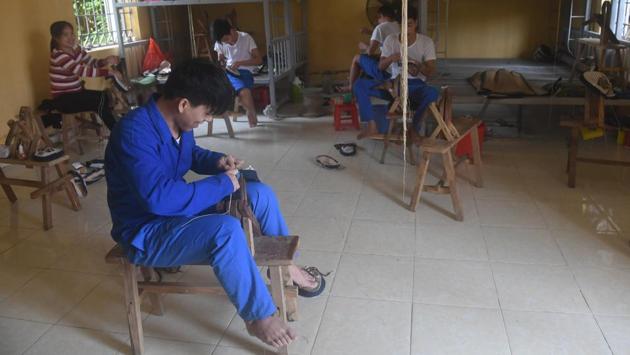 Inmates sew shoes at a drug rehabilitation centre. Most inmates stay for one or two years, or up to four if they are deemed unfit for release, and are subject to a range of daily labour -- from farming cashews to making sportswear for Western clothing brands, which they can sometimes earn a meagre salary from. (AFP) 