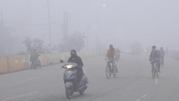 Commuters amid dense fog on a cold morning in Amritsar on Wednesday.(Sameer Sehgal/HT)