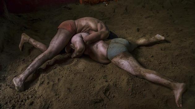 Pehelwans battle it out in the ring at Hanuman Akhada. Under a coach’s watchful eye, they lock arms, lunging for their opponents’ legs as they try to flip them onto their backs and into submission. Many Indian wrestlers start out in the pit and later gain proficiency on a mat --the standard arena for most international bouts. (Dar Yasin / AP) Pehelwans battle it out in the ring at Hanuman Akhada. Under a coach’s watchful eye, they lock arms, lunging for their opponents’ legs as they try to flip them onto their backs and into submission. Many Indian wrestlers start out in the pit and later gain proficiency on a mat --the standard arena for most international bouts. (Dar Yasin / AP)