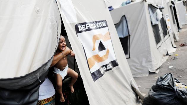 A Venezuelan woman holds her baby inside a tent outside a shelter in Boa Vista. In Roraima, the rural state of which Boa Vista is the capital, the governor has decreed a “social emergency,” putting local services on alert for mounting health and security demands. “Shelters are already crowded to their limit,” said George Okoth-Obbo, operations chief for the United Nations High Commission on Refugees. “It is a very tough situation.” (Nacho Doce / REUTERS) A Venezuelan woman holds her baby inside a tent outside a shelter in Boa Vista. In Roraima, the rural state of which Boa Vista is the capital, the governor has decreed a “social emergency,” putting local services on alert for mounting health and security demands. “Shelters are already crowded to their limit,” said George Okoth-Obbo, operations chief for the United Nations High Commission on Refugees. “It is a very tough situation.” (Nacho Doce / REUTERS)