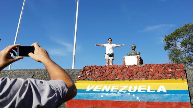 A Venezuelan man takes a picture of his wife after they crossed the border into Pacaraima. As Venezuelans continue to pore through, a senior official in Brazil’s foreign ministry, on anonymity, said the country will not close its borders. Okoth-Obbo meanwhile said his UN agency and Brazil’s government are also discussing ways to move refugees to larger cities. (Nacho Doce / REUTERS) A Venezuelan man takes a picture of his wife after they crossed the border into Pacaraima. As Venezuelans continue to pore through, a senior official in Brazil’s foreign ministry, on anonymity, said the country will not close its borders. Okoth-Obbo meanwhile said his UN agency and Brazil’s government are also discussing ways to move refugees to larger cities. (Nacho Doce / REUTERS)