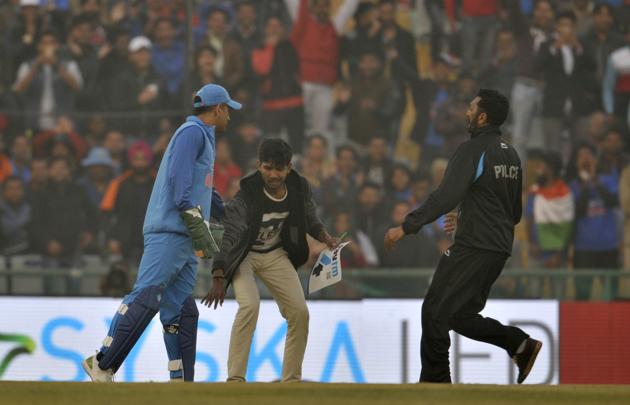 A fan breached security to touch former skipper MS Dhoni’s feet during the ODI match. (Ravi Kumar/HT)