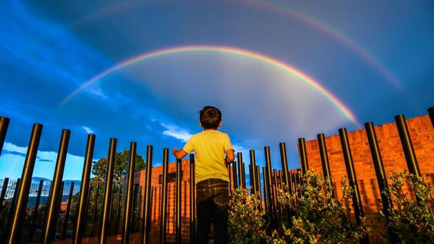 A boy looks at a rainbow during a sunset in Bogota, Spain on December 13, 2017. (Luis Acosta / AFP) A boy looks at a rainbow during a sunset in Bogota, Spain on December 13, 2017. (Luis Acosta / AFP)