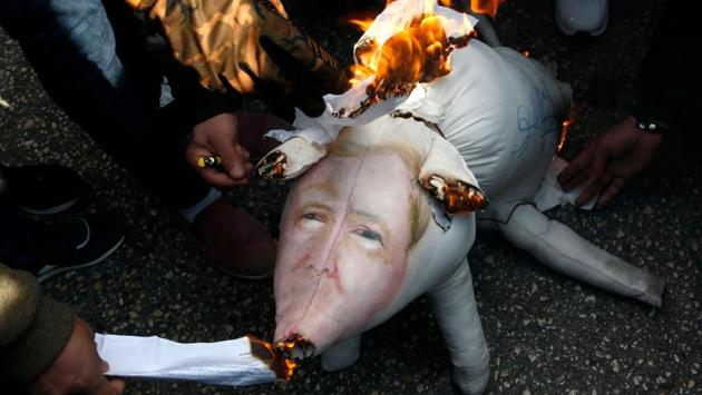 Palestinian protestors burn stuffed pillows in the shape of a pig and bearing an image of Israeli President Benjamin Netanyahu during a demonstration in the West Bank town of Hebron on December 13, 2017. (Hazem Bader / AFP) Palestinian protestors burn stuffed pillows in the shape of a pig and bearing an image of Israeli President Benjamin Netanyahu during a demonstration in the West Bank town of Hebron on December 13, 2017. (Hazem Bader / AFP)