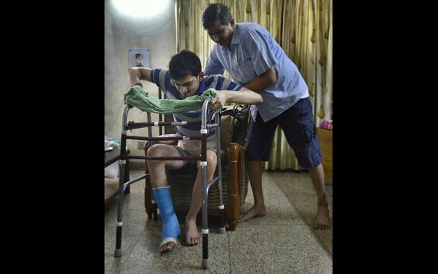 Ravi Rai, the patient who was wrongly operated, takes his father’s help to move.(Raj K Raj/HT File Photo)