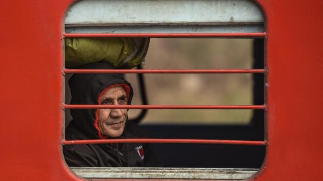 An old man in a passenger train on a cold morning at Nizamuddin Railway station in New Delhi on Tuesday. (Burhaan Kinu / HT Photo) 