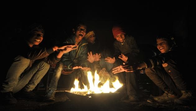 Children sit around the bonfire in Mohali on Friday. (Ravi Kumar/HT) Children sit around the bonfire in Mohali on Friday. (Ravi Kumar/HT)