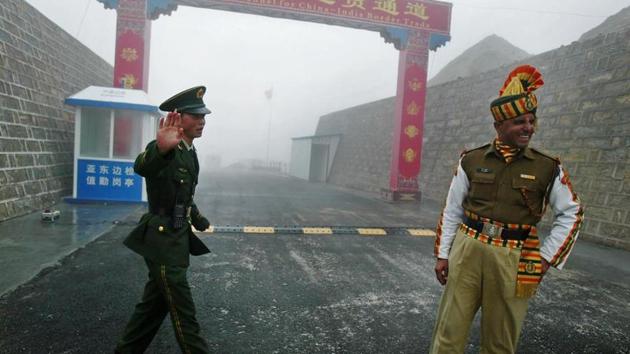 A Chinese soldier stands next to an Indian counterpart at the Nathu La border crossing between India and China in Sikkim state. (AFP File Photo) A Chinese soldier stands next to an Indian counterpart at the Nathu La border crossing between India and China in Sikkim state. (AFP File Photo)