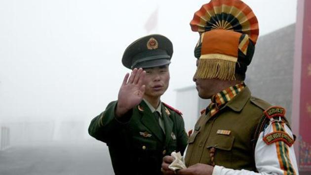 (FILES) This file photo taken on July 10, 2008 shows a Chinese soldier (L) gesturing next to an Indian soldier at the Nathu La border crossing between India and China in India's northeastern Sikkim state. (AFP) (FILES) This file photo taken on July 10, 2008 shows a Chinese soldier (L) gesturing next to an Indian soldier at the Nathu La border crossing between India and China in India's northeastern Sikkim state. (AFP)