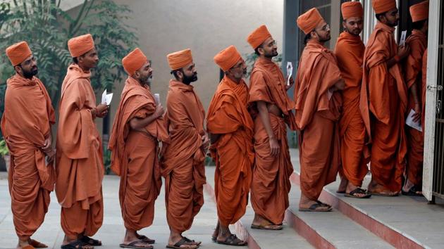 Hindu saints stand in a queue to casts their votes at a polling station during the final phase of Gujarat state assembly election on the outskirts of Ahmedabad on Thursday. (Amit Dave / REUTERS) 