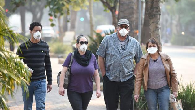 Visitors wearing masks walk to protect themselves from smoke and ash from the Thomas Fire walk on State Street, the main shopping street in Santa Barbara, California. The fire has been responsible for poor air quality throughout Southern California, affecting business in the stores that are staying open. (Robyn Beck / AFP) Visitors wearing masks walk to protect themselves from smoke and ash from the Thomas Fire walk on State Street, the main shopping street in Santa Barbara, California. The fire has been responsible for poor air quality throughout Southern California, affecting business in the stores that are staying open. (Robyn Beck / AFP)