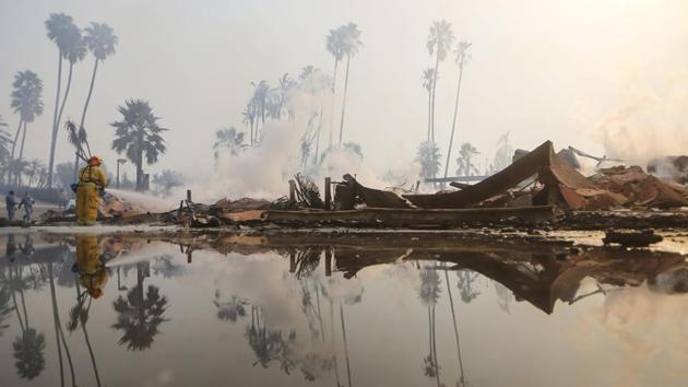 A firefighter sprays water at the remains of an apartment complex destroyed by the Thomas Fire on December 5, 2017 in Ventura, California. The fire has destroyed more than 1,000 structures, including about 750 homes, in coastal communities in Southern California with thousands of firefighters contending with it around the clock. (Mario Tama / Getty Images / AFP ) A firefighter sprays water at the remains of an apartment complex destroyed by the Thomas Fire on December 5, 2017 in Ventura, California. The fire has destroyed more than 1,000 structures, including about 750 homes, in coastal communities in Southern California with thousands of firefighters contending with it around the clock. (Mario Tama / Getty Images / AFP )