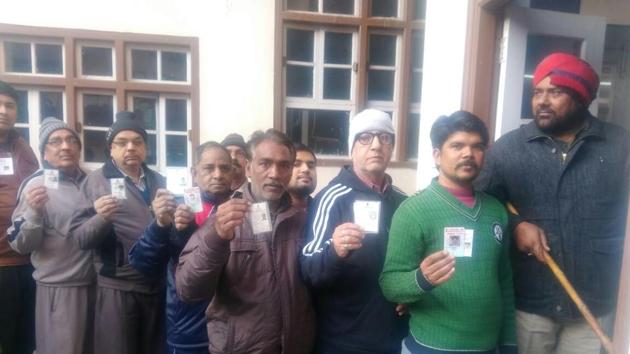 Voters stand in a queue to cast their votes outside a polling station in Amritsar. (Sameer Sehgal/HT)