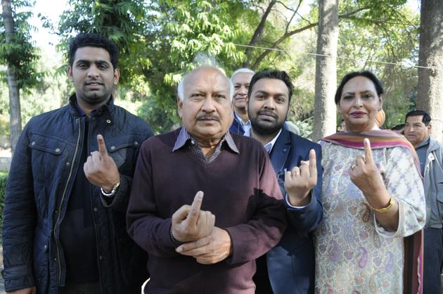 Health minister Brahm Mohindra with his family showing ink mark after casting his vote in Patiala . (Bharat Bhushan/HT)