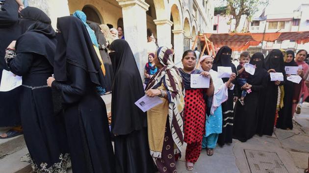 Women voters wait in queue to cast their votes in the second phase of assembly elections in Daryapur, Ahmedabad.(PTI Photo)