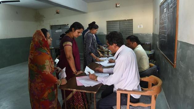 Polling officials verify electoral documents of voters in a re-polling centre at Nava Naroda on the outskirts of Ahmedabad on December 17. (AFP Photo) Polling officials verify electoral documents of voters in a re-polling centre at Nava Naroda on the outskirts of Ahmedabad on December 17. (AFP Photo)