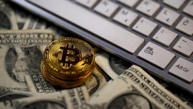 Bitcoin (virtual currency) coins placed on Dollar banknotes, next to computer keyboard, are seen in this illustration picture, November 6, 2017. (Reuters File Photo) Bitcoin (virtual currency) coins placed on Dollar banknotes, next to computer keyboard, are seen in this illustration picture, November 6, 2017. (Reuters File Photo)