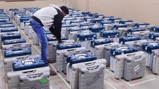 An election official arranging the Electronic Voting Machines (EVM) at a distribution centre before moving to their respective polling stations ahead of the second phase of polling, in Ahmedabad on December 13.(PTI Photo)