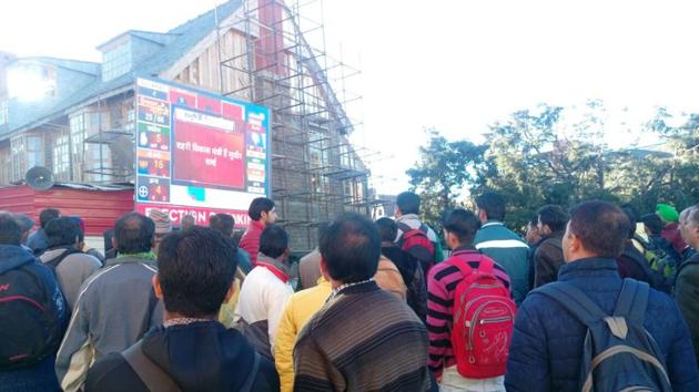 People watching live updates of HP assembly results at Scandal Point on Mall road in Shimla on Monday. (Deepak Sansta/HT)