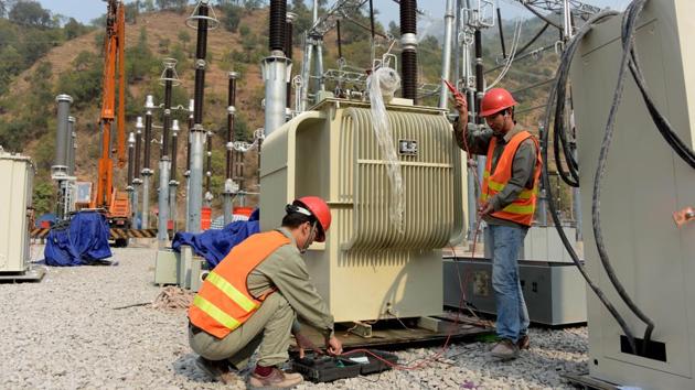 Chinese engineers work on a power distribution point in Chattar Klass. At the confluence of the Neelum and Jhelum, the gigantic underground cathedral of concrete and steel is near completion -- the four generators are in place, waiting for the transformers and the network to be connected. (Sajjad Qayyum / AFP)