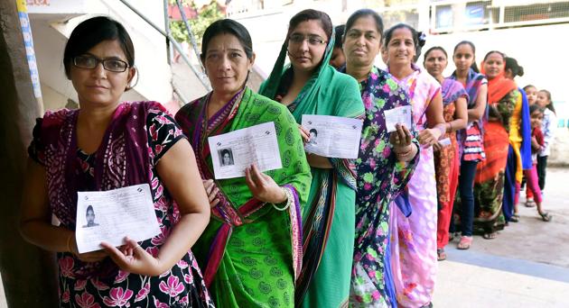 Women wait to cast their vote during repolling at a booth in Daskroi constituency, at Ahmedabad.(PTI)