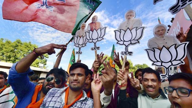 BJP workers celebrate their victory in the assembly elections near the party office 'Kamlam' in Gandhinagar on Monday.(PTI)