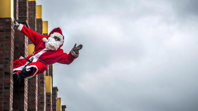 In Berlin, Santa got his adventurous streak out, dangling from the top of the Kollhoff tower to get the Christmas cheer going. (John Macdougall / AFP)