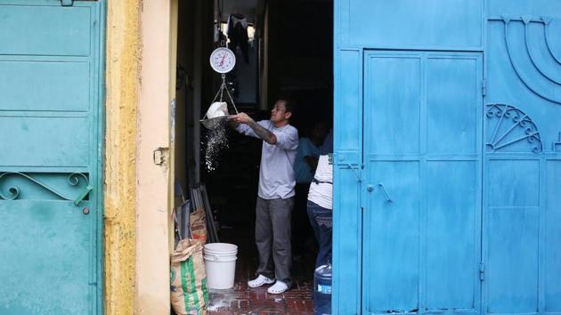 Roberto Renderos, weighs flour at their bakery ahead of the day’s work. Renderos and Gomez now run a bakery that employs other ex-gangsters. The church has been a lifeline to reforming gang members and has been a lifeline, also offering food, accommodations and spirituality. (Jose Cabezas / REUTERS) 