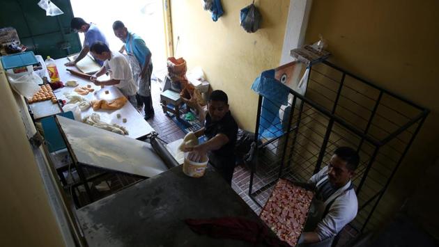 Members of the Huellas de Esperanza work the line in their bakery at the Eben Ezer church. Rejected by a society weary of violence, they nonetheless struggle to eradicate the stain of gang life. (Jose Cabezas / REUTERS) 