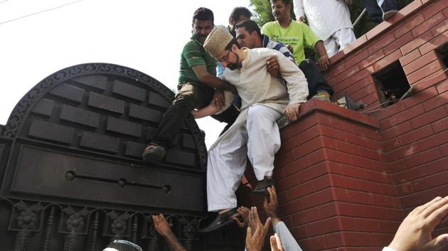 Mirwaiz Umar Farooq (centre), chairman of the moderate faction of All Parties Hurriyat (Freedom) Conference, climbs down the gate of his house to visit the Martyrs Graveyard to pay tribute and protest against the civilian killings in Srinagar in July 2016. (Waseem Andrabi / HT Photo) Mirwaiz Umar Farooq (centre), chairman of the moderate faction of All Parties Hurriyat (Freedom) Conference, climbs down the gate of his house to visit the Martyrs Graveyard to pay tribute and protest against the civilian killings in Srinagar in July 2016. (Waseem Andrabi / HT Photo)