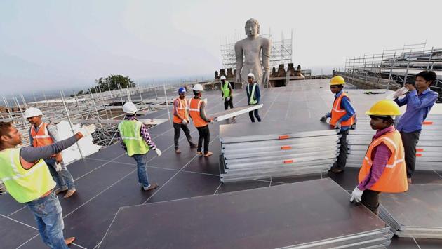 Workers fix boards in the scaffolds to prepare a platform near the statue. The structure will include three lifts, necessary to reach the statue’s top for its anointment and will accommodate nearly 6,000 people. (PTI)