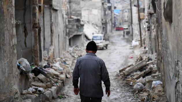 Syrian Khayro Moselmani walks amidst debris in the former rebel-held Kalasse neighbourhood in the northern Syrian city of Aleppo on December 16.(AFP)