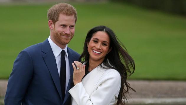 Britain's Prince Harry with his fiancée Meghan Markle as she shows off her engagement ring whilst they pose for a photograph in the Sunken Garden at Kensington Palace in west London, following the announcement of their engagement (AFP) Britain's Prince Harry with his fiancée Meghan Markle as she shows off her engagement ring whilst they pose for a photograph in the Sunken Garden at Kensington Palace in west London, following the announcement of their engagement (AFP)