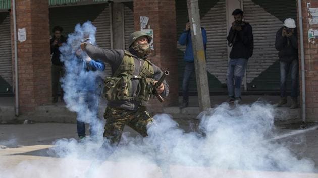 An Indian police man throws back an exploded tear gas shell at Kashmiri protesters during a protest in Srinagar. (AP File Photo) An Indian police man throws back an exploded tear gas shell at Kashmiri protesters during a protest in Srinagar. (AP File Photo)