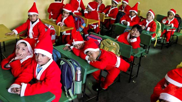 Children dressed in Santa Claus costumes sit inside a classroom before participating in Christmas celebrations at a school in Chandigarh on Wednesday. (Ajay Verma / REUTERS)